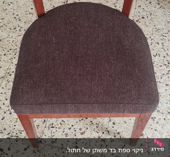 כיסא עם מושב מרופד וכלי ניקוי על הרצפה
